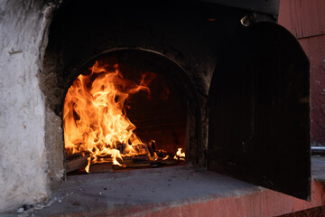Fire and burn coals in stone oven. Oven made of bricks and clay.