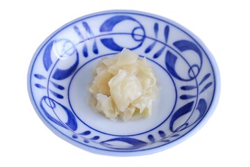 A close up shot of some pickled ginger on plate on white background.