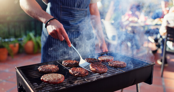 Barbecue, cooking and man with burgers outdoor backyard for meal at reunion, social event or lunch on terrace. Party, food and male person grilling patty, beef or meat for bbq dish on weekend at home - Powered by Adobe