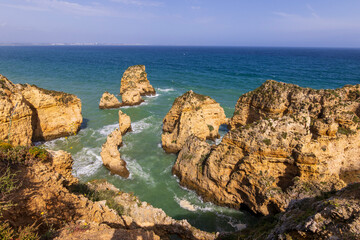 Rocks and cliffs at the edge of the Atlantic Ocean in Portimao in the Algarve in Portugal.