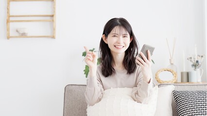 スマホを操作しながら指差しをする女性