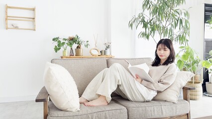 Obraz premium ソファで本を読む女性