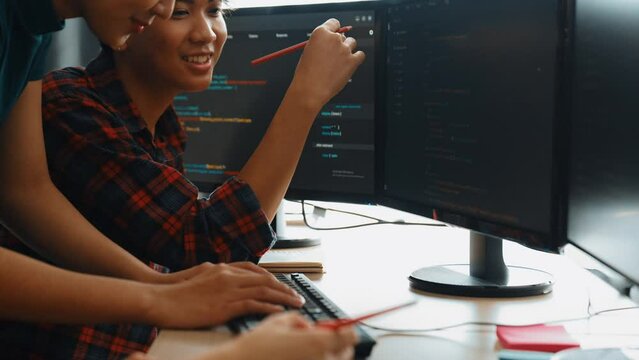 Slow motion back end software developer engineer for computer programming working together on debugging writing computing code, solving complex algorithms display on monitor in office. Burgeoning