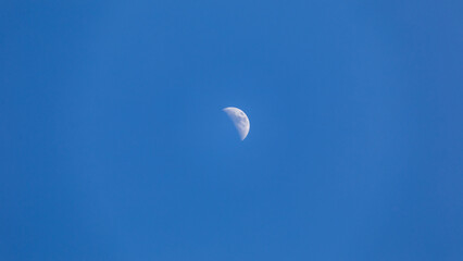 Half moon in blue sky, day moon, daytime moon in clear air