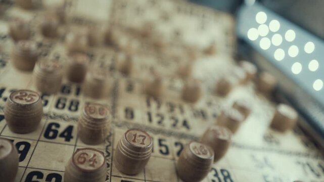 Macro video of a Bingo board, studio lights, 120 fps, slow motion, wooden chip digits, Raw footage, lottery desk game, card numbers, crane pull back rotating movement