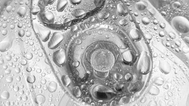 A close-up reveals the tantalizing sight of water droplets adorning the aluminum lid of the can, hinting at the refreshing drink within. The pull tab beckons for exploration. Beverage background.

