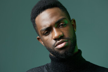 Obraz premium Confident man in a black turtleneck sweater looking directly at the camera with a serious expression
