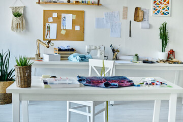 A white table in a brightly lit atelier, showcasing a denim garment ready for upcycling.