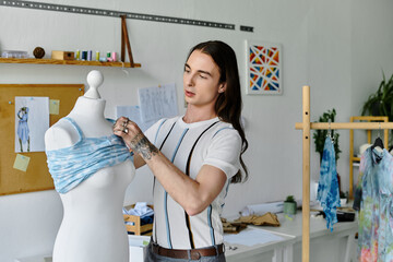 A young man meticulously adjusts a blue garment on a mannequin in his DIY clothing restoration...