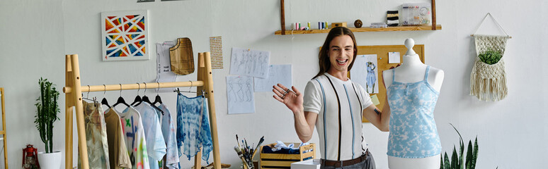 A young man stands in his DIY clothing restoration atelier, surrounded by his work. He is...