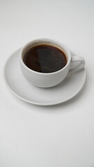 A glass of black coffee in a white glass isolated on a white background
