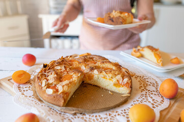 Homemade fresh baked apricot cake served by a woman with apron