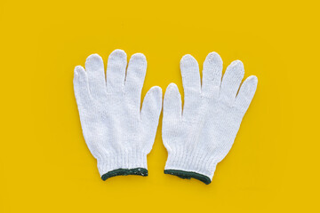 White cotton gloves on yellow background.