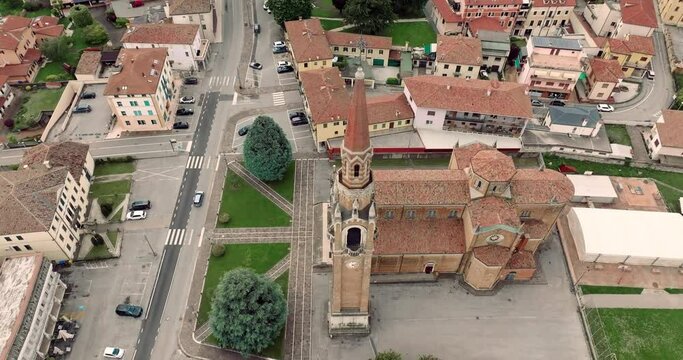 Aerial view cityscape Cornuda Italy. The architecture of the cathedral with the bell tower in the urban landscape of the city. High quality 4k footage