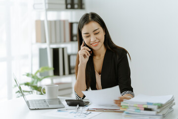 Fototapeta premium Shot of an Asian young businesswoman working on a laptop computer in her workstation.Portrait of Business people employee freelance online marketing