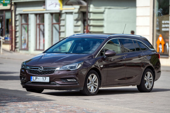 Brown Opel Astra K (B16) Sports Tourer station wagon parked on the street