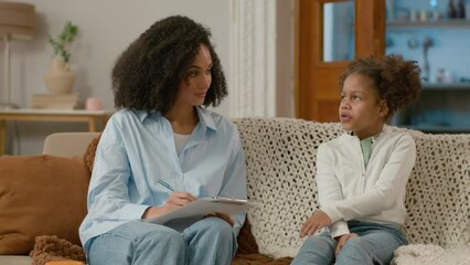 African American woman excited child psychologist patient conversation talking communication happy little girl consultation mental health doctor writing clipboard speak emotional wellbeing development