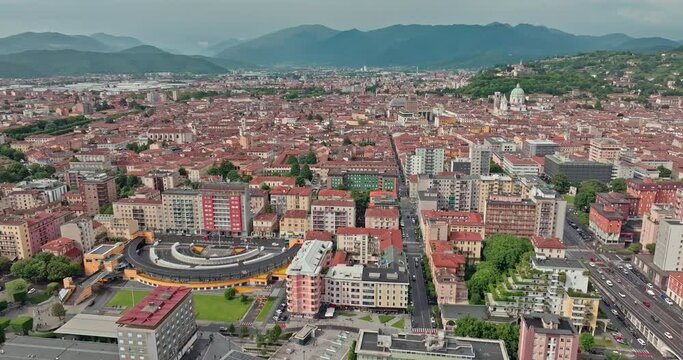 Aerial cityscape of Brescia Italy. Beautiful architecture, historical houses and the cathedral in a tourist town with a mountain view. High quality 4k footage