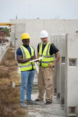 Portrait African engineer man working with caucasian engineer man at precast cement outdoor factory	
