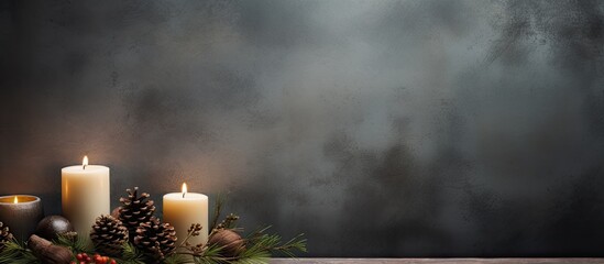 A copy space image featuring a grey background adorned with burning candles fir tree branches pine cones and hazelnuts
