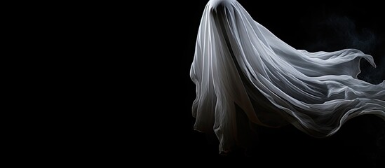 A Halloween themed ghost crafts a ghost on a black background creating a perfect copy space image for text The image offers creative inspiration with its blank canvas and top down perspective