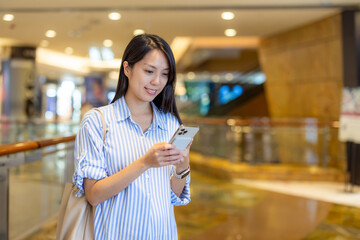 Asian pregnant woman use of mobile phone in shopping mall
