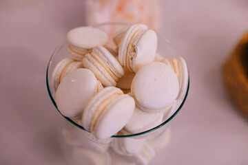 delicious macarons with white filling in a glass plate.