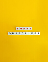SMART (Specific, Measurable, Achievable, Relevant, and Time-bound) Objectives. Concept of Developing Key Business Objectives.  Text on Block Letter Tiles on Yellow Background. Minimal Aesthetics.
