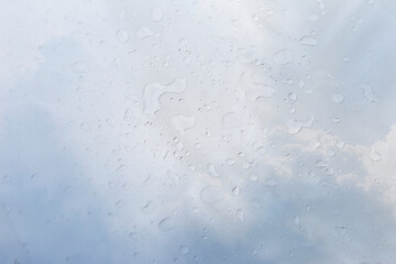 Clear water drop over blurred rain cloud background, weather and season concept