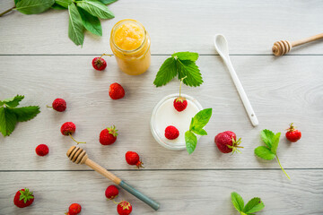 homemade sweet yogurt in a jar with strawberries, on a wooden table