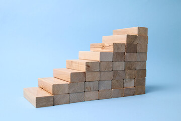 Wooden block stairs isolated on blue background. Space for text or concept.