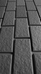 Naklejka premium Stone tiles receding into the distance are arranged in even rows. Black and white stock photo for stone backgrounds