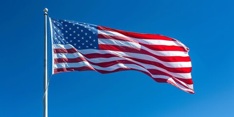 Fototapeta premium Majestic American Flag Waving in Clear Blue Sky