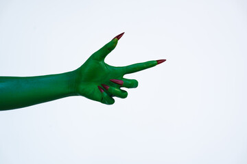 A green monster hand with long nails, isolated against a dark background, evokes horror and fear....