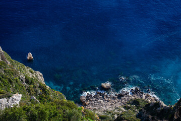 Rocky Ocean coast with dark blue waters and forest-covered hillsides