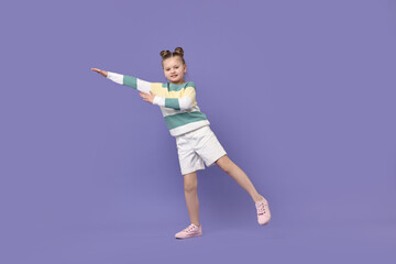 Cute little girl dancing on violet background