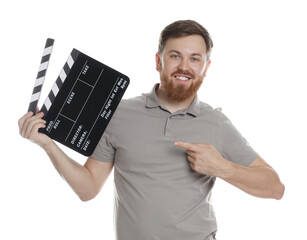 Making movie. Smiling man pointing at clapperboard on white background