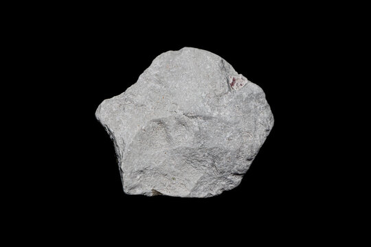 Natural rough kaolinite (kaolin) ore on dark background. A clay mineral used in many industries as porcelain, ceramic, paper and paint