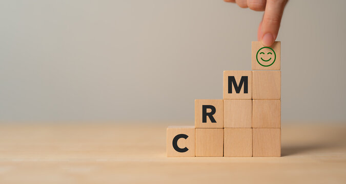 CRM, Customer relationship management concept. Customer satisfaction, retention strategies. CRM or customer loyalty program banner. Wooden cube blocks with CRM symbols on minimal background.