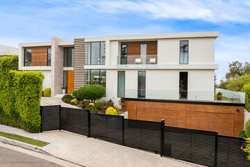 Contemporary house on a corner lot with lush foliage © Wirestock