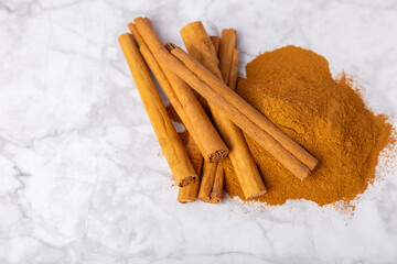 Ceylon cinnamon.Cinnamon sticks on a textured wooden background. Cinnamon roll and powder. Spicy spice for baking, desserts and drinks. Fragrant ground cinnamon. Close-up. Place for text. copy space