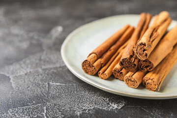Ceylon cinnamon.Cinnamon sticks on a textured wooden background. Cinnamon roll and powder. Spicy spice for baking, desserts and drinks. Fragrant ground cinnamon. Close-up. Place for text. copy space