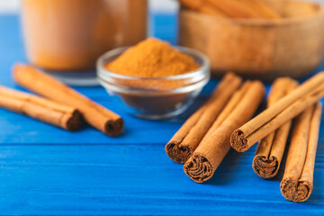 Ceylon cinnamon.Cinnamon sticks on a textured wooden background. Cinnamon roll and powder. Spicy spice for baking, desserts and drinks. Fragrant ground cinnamon. Close-up. Place for text. copy space