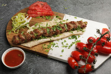 Shot of fresh vegetables and kebab on a wooden cutting board