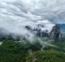 Amazing panoramic view of the rocks in the Meteora Valley, mysteriously shrouded in mist and low clouds, near Kastraki in Greece.