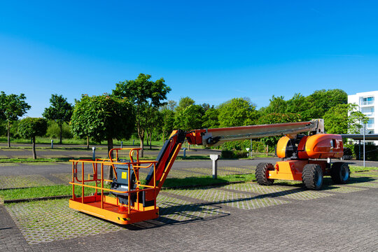 Mobile construction hoist for lifting people in the parking lot under blue sky.