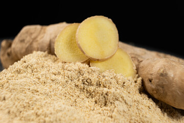 Ground ginger as a fine dry powder, macro on a black background