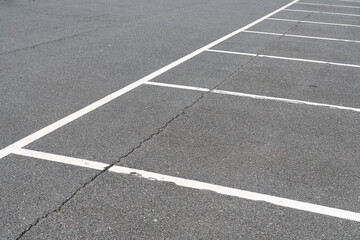 White markings of empty parking lot on gray asphalt. Top view.