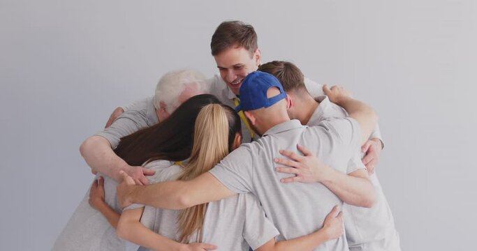 Volunteer team in common hug, completing training tasks with supervisor, community supporting each other demonstrating professionalism, spirit, following instructions, group teambuilding together 