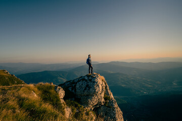 A man who hikers enjoys a break look at the top of the mountain at sunset or sunrise adventure travel. 